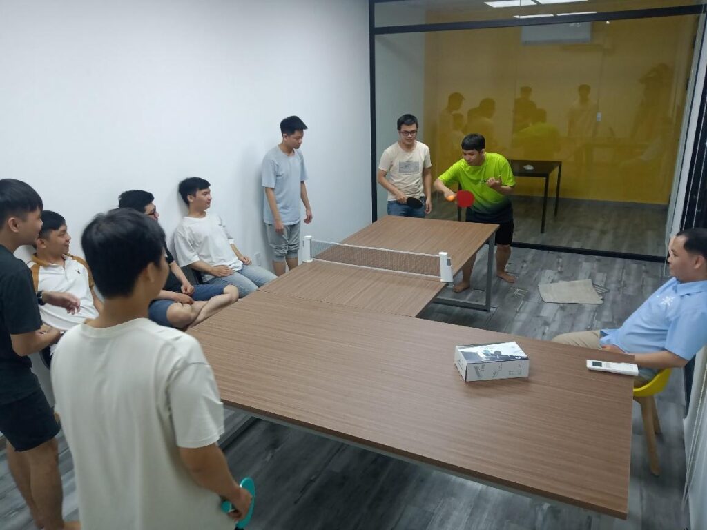 Thầy giáo đang chỉ cho học trò cách chơi ping pong.